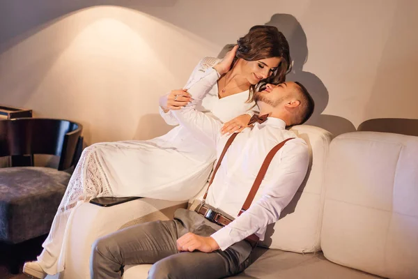 Пара в праздничной одежде сидит на диване и хочет поцеловаться — стоковое фото