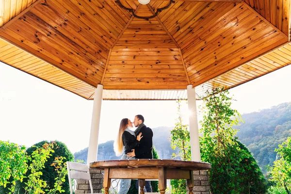 Coppia baci nel gazebo sullo sfondo della foresta — Foto Stock