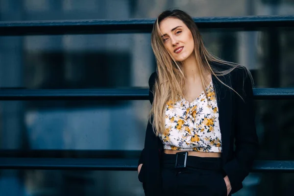 Young woman with a beautiful makeup in a black suit near the wa — Stock Photo, Image