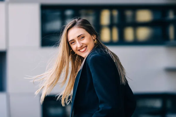 La joven feliz en traje negro sonríe y mira la cámara. cerrar. — Foto de Stock