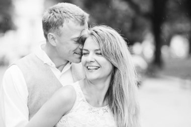 Bir adam kızın kulağına bir şey fısıldıyor ve o gülümsüyor. Park.