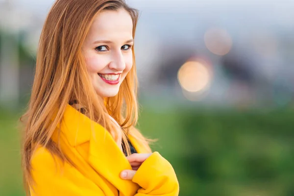 Ritratto di ragazza felice in cappotto giallo. vicino. bel sorriso — Foto Stock