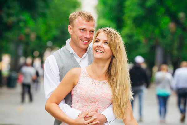 Парень обнимает девушку и смотрит в камеру. Парк. праздничная ткань
