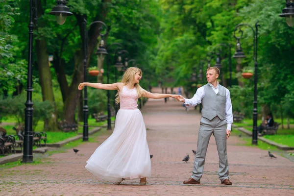 Belle danse des jeunes mariés dans le parc. grâce. arbres verts et — Photo