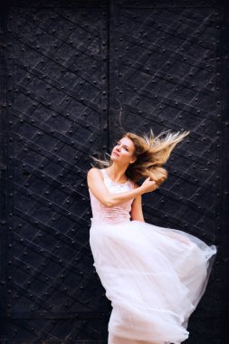 Gelinin güzel bir elbisesi var, saçlarını arkaya doğru sallıyor.