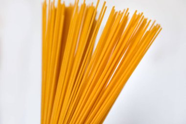 Erkek eli beyaz arka planda spagetti tutuyor. Kapat.