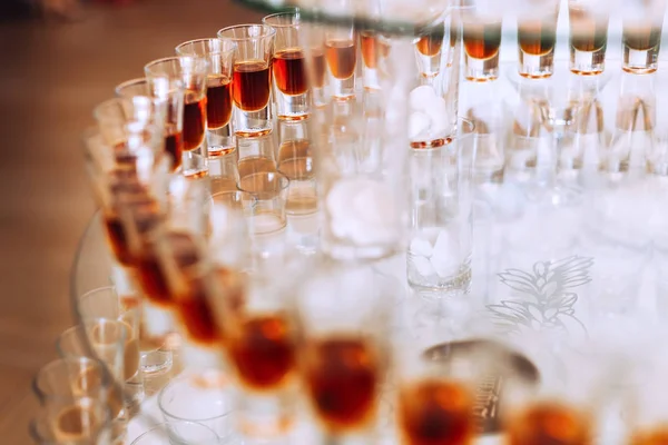 Bicchieri con bevande alcoliche su uno stand trasparente. chiudere u — Foto Stock
