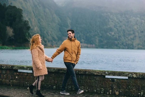 Marcher au bord du lac. Le mec et la fille se tiennent la main et les toilettes — Photo