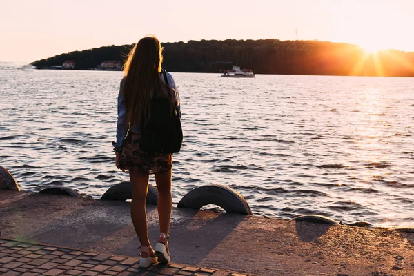 Das Mädchen am Ufer des Sees bewundert den Sonnenuntergang und die Shi — Stockfoto