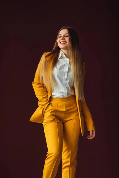 Hermosa chica en un traje amarillo sonríe. ropa casual para busi — Foto de Stock