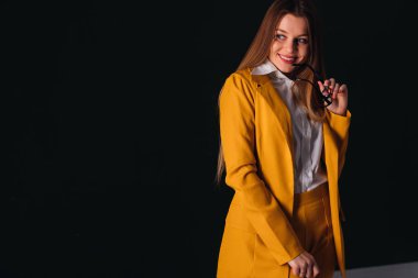 Sarı takım elbise ve eyeglasse güzel seksi genç iş kadını