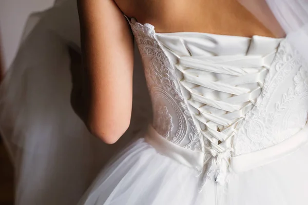 Bruden i en vacker vit klänning och korsett med ett band. — Stockfoto