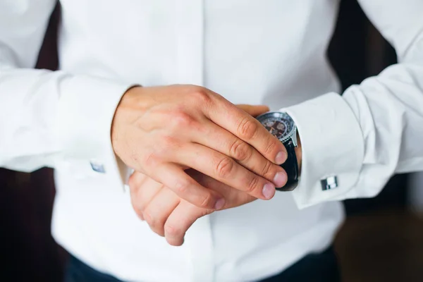 Крупним планом стильний годинник на руці нареченого, який дивиться на циферблат — стокове фото