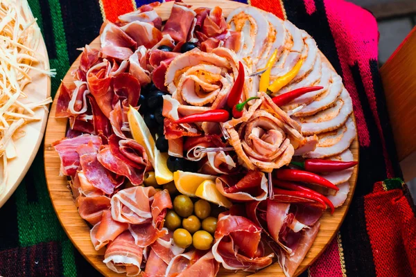 Tranches de différentes sortes de viande sur une assiette en bois décorée wi — Photo