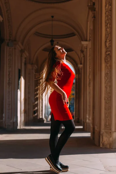 Menina em um vestido vermelho acenando seu cabelo e posando. roupas elegantes . — Fotografia de Stock