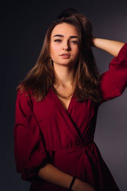 marsala elbise güzel genç kadın kameraya bakmak. Poz. C