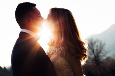 Güzel saç stili ve damadın öpüştüğü bir gelin.