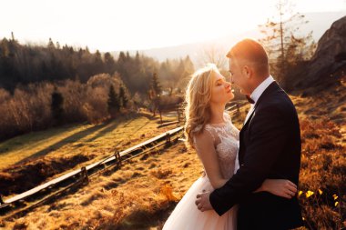 Gelin gözlerini kapadı ve damat ona arkadan sarıldı.