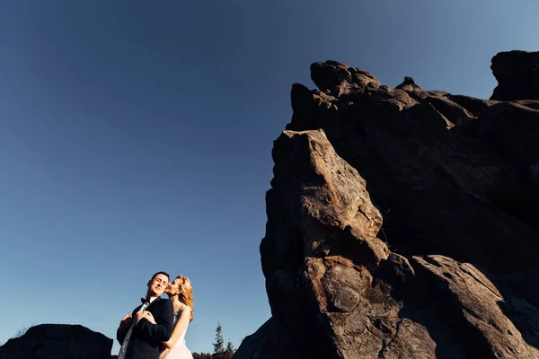 La mariée embrasse le marié de l'arrière et baisent sur le ch — Photo