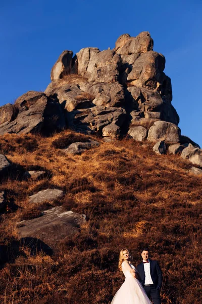 O penhasco no alto do monte. o noivo olha para a noiva. — Fotografia de Stock