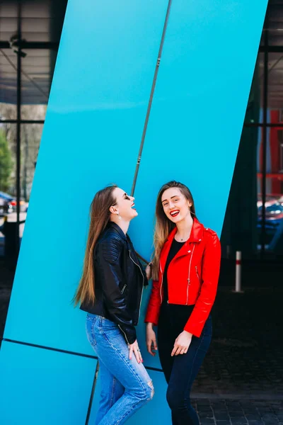 Giovani ragazze in piedi insieme in giacca di pelle vicino alla costruzione di un — Foto Stock