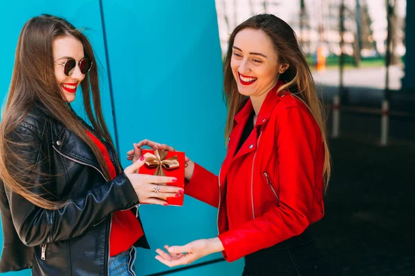  Deri ceketli kız, inşaatta arkadaşına hediye veriyor.