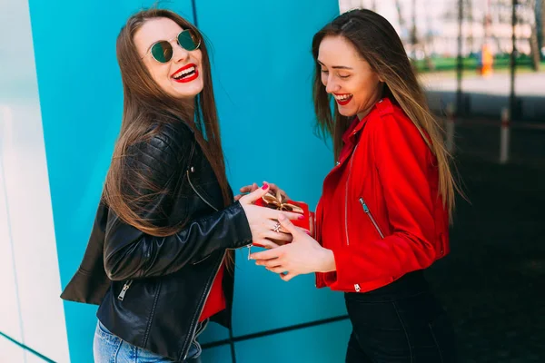 Mädchen in Lederjacke und Sonnenbrille gibt eine Schachtel mit Klebeband an — Stockfoto
