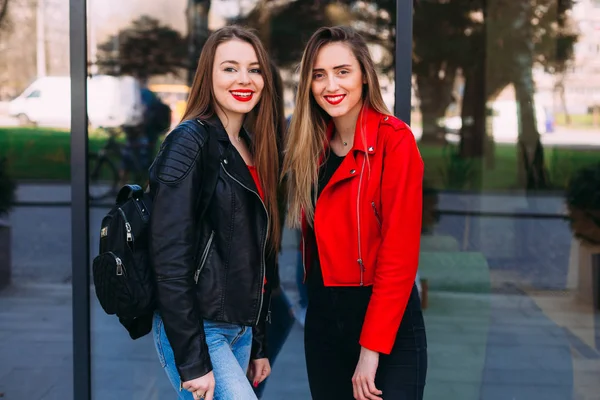 Dos amigas jóvenes se ponen de pie juntas y miran la cámara. cita — Foto de Stock