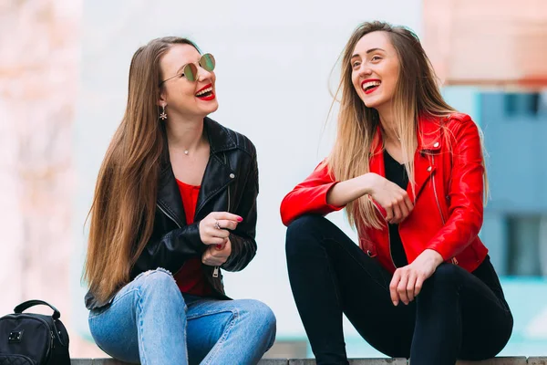 Twee stijlvolle mooie meisjes zitten op de trap en glimlachen. styl — Stockfoto
