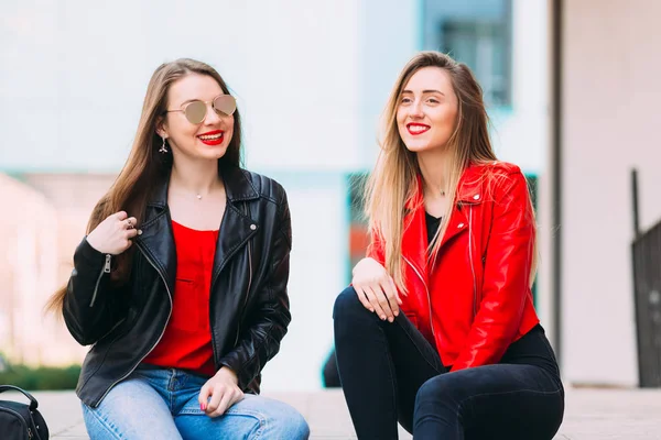 Chicas sentadas y sonrientes. Ganando equipo urbano de moda, cuero ja — Foto de Stock