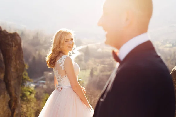 Bride look at camera and smiles. profile of the groom in the for — Stock Photo, Image