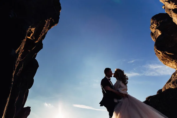 Silhouette of newlyweds hugging each other on a background of cl. —  Fotos de Stock