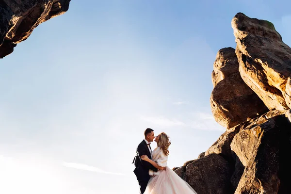 Perfil dos recém-casados nos braços uns dos outros em um fundo de — Fotografia de Stock