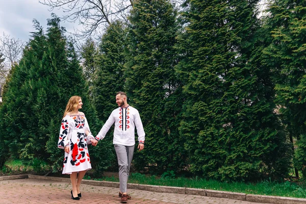 Pasgetrouwden in geborduurde kleren lopen in het park. De gu — Stockfoto