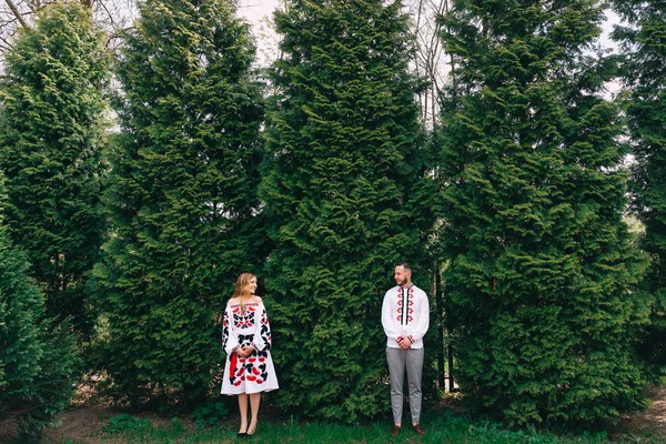 Хлопець і дівчина стоять біля дерев і дивляться на камеру. вбудувати — стокове фото