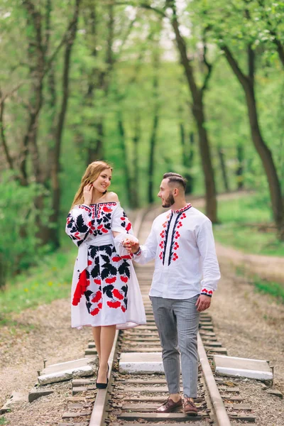 Mariés en vêtements brodés marchent le long du chemin de fer i — Photo