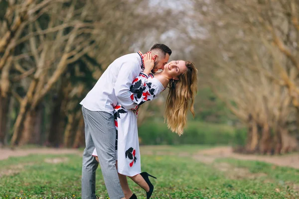 O tipo abraça e beija a rapariga. roupas bordadas. parque . — Fotografia de Stock