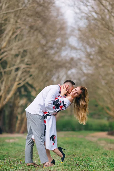 Le mec embrasse et embrasse la fille. vêtements brodés. parc . — Photo