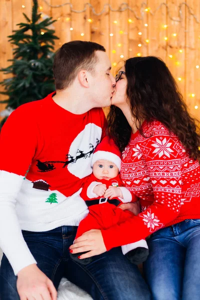 Ouders kussen tegen de achtergrond van de kerstboom en th — Stockfoto