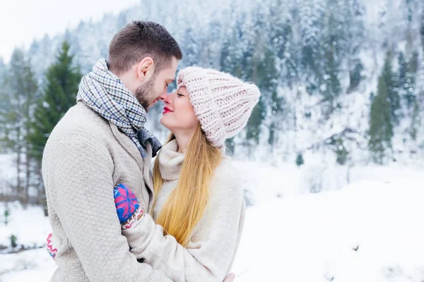 Парень и девушка обнимаются и смотрят друг на друга. очаровательная зима в Стоковая Картинка