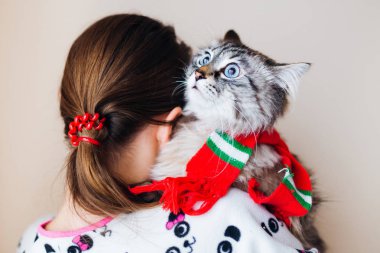 bir ev saç modeli ile bir kız kameraya geri duruyor ve bir tutar 