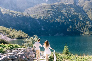 adam elinden kız tutar ve taş boyunca yürümek