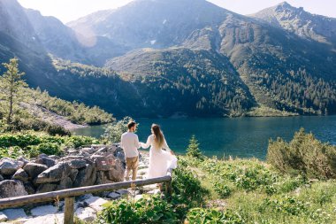 Kız ve erkek el ele tutuşup taş yolda yürüyorlar. güzel 