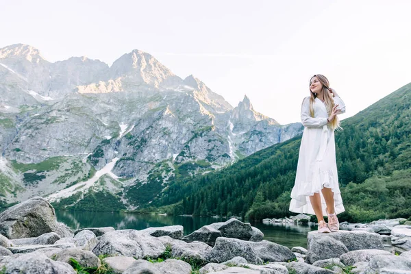 Menina em um vestido branco cruzou os braços e está em um grande para — Fotografia de Stock