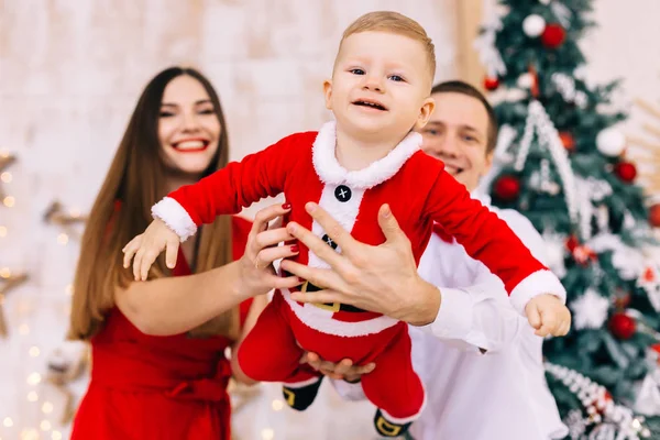 Bébé volant en costume de Père Noël au premier plan. papa et maman tiennent — Photo