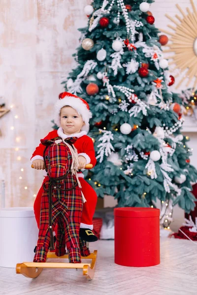 Bambino in costume da Babbo Natale a dondolo cavallo guardare la fotocamera su t — Foto Stock