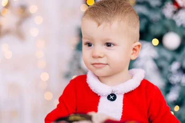 Ritratto di bambino in costume da Babbo Natale su sfondo sfocato. clos — Foto Stock