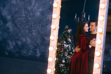 Ampullü mavi duvarın yanındaki ayna. Çifti yansıtıyor