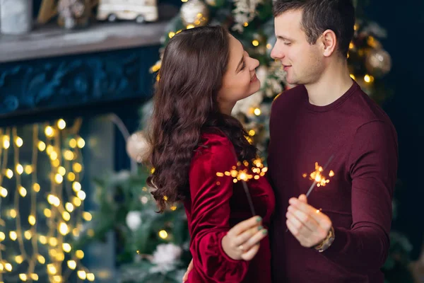 Namorado e namorada olhar um para o outro e segurar sparklers . — Fotografia de Stock