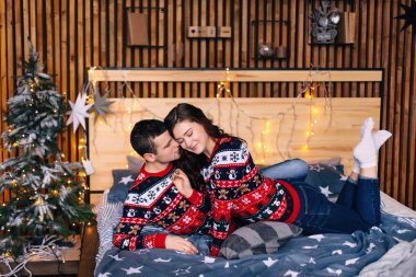 Kız ve erkek gözlerini kapatıp yatağa uzanıyorlar. oda dekorasyonu